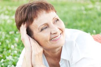 A photo of a female audiologist providing a hearing aid consultation to a middle-aged male client with brown skin and a beard.