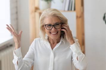 A photo of a female audiologist providing a hearing aid consultation to a middle-aged male client with brown skin and a beard.